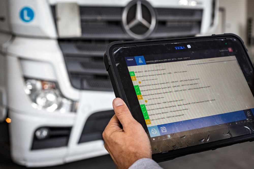 Szakember diagnosztikai táblagéppel ellenőrzi egy Mercedes teherautó vezetéstámogató és ADAS-rendszereinek működését.